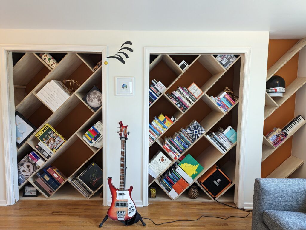 45-degree bookshelves inside several closets. An array of books and objects are sitting on the shelves