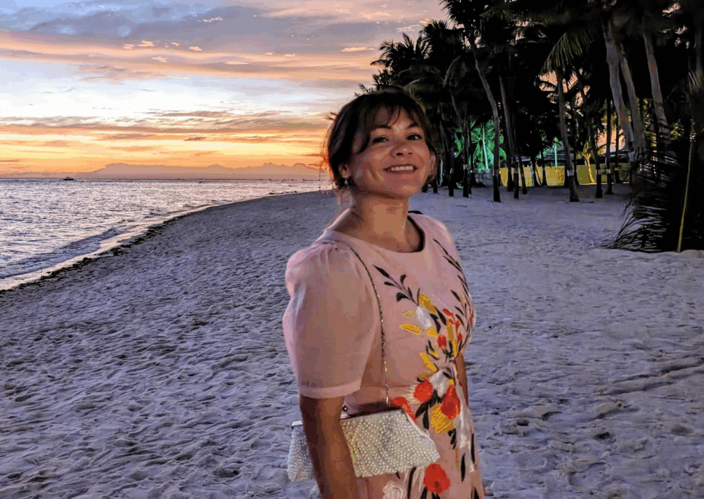 Melissa smiling and standing on a beach